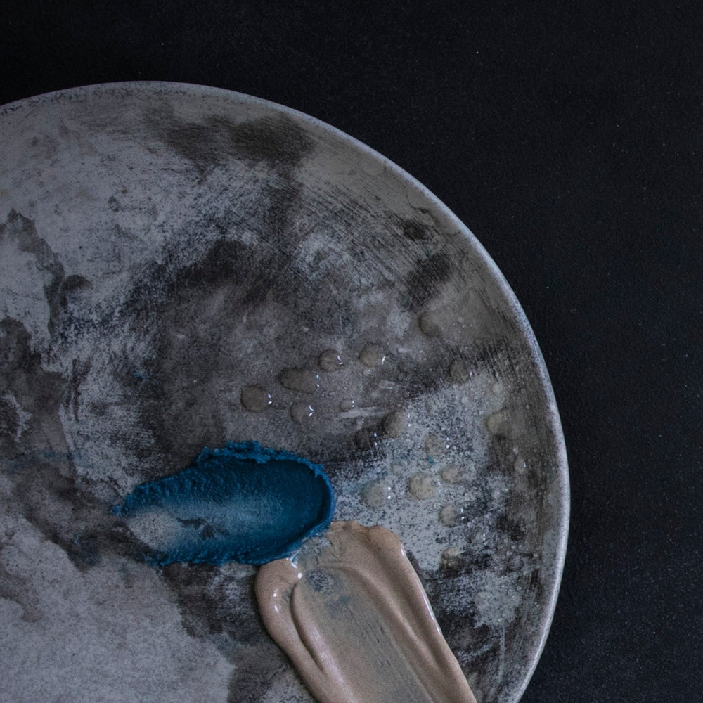 Decorative plate with blue and beige items on a dark background