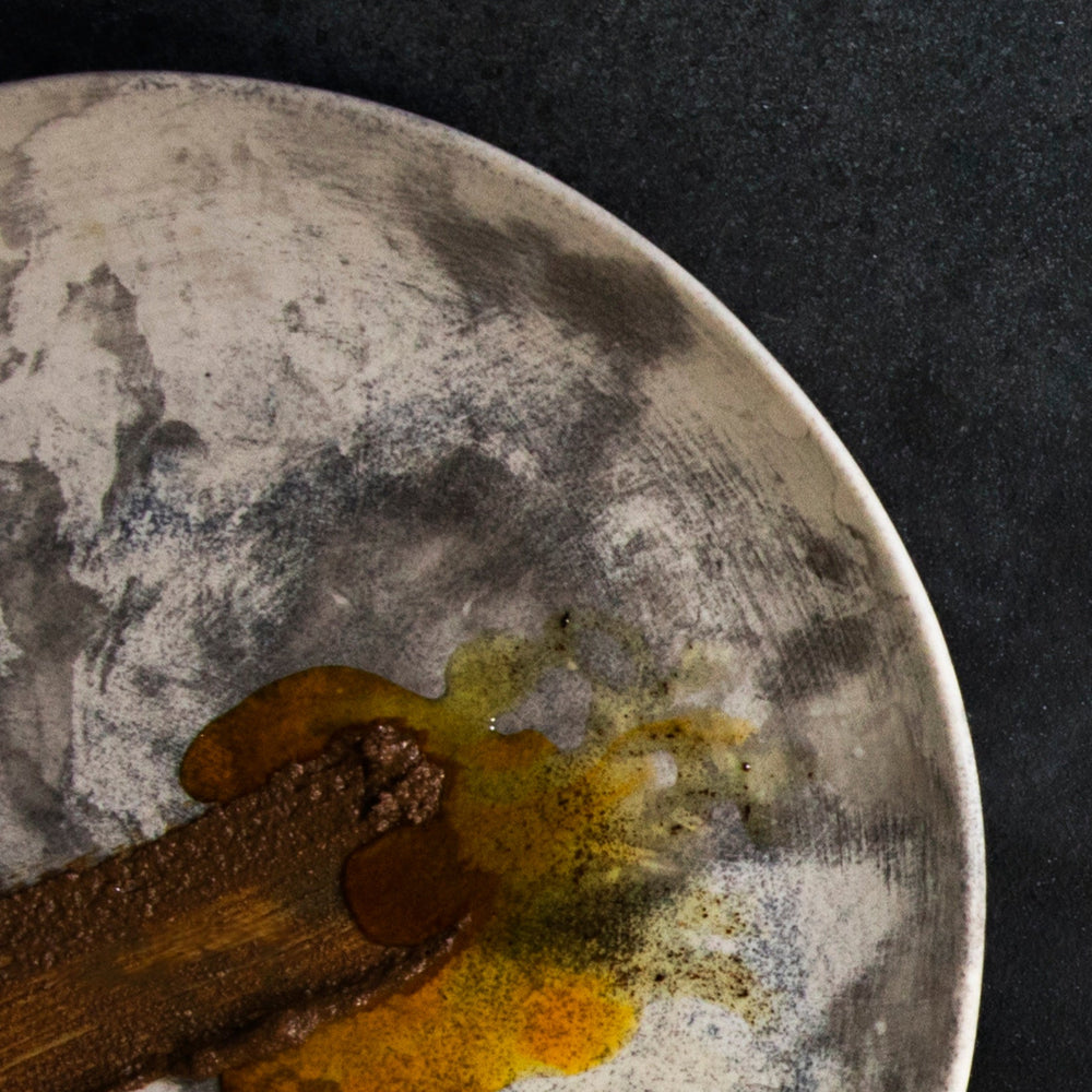 Decorative plate with brown and beige items on a dark background