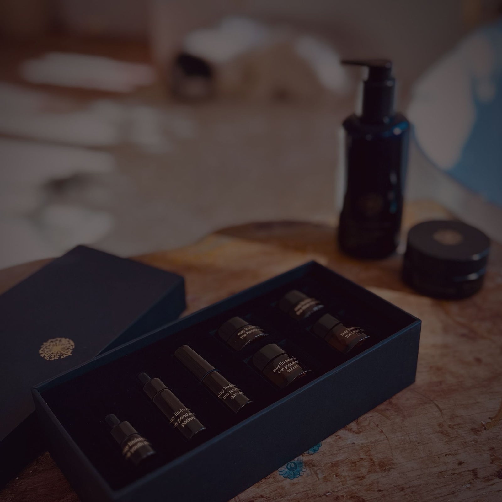 Set of small bottles in a black box on a wooden surface