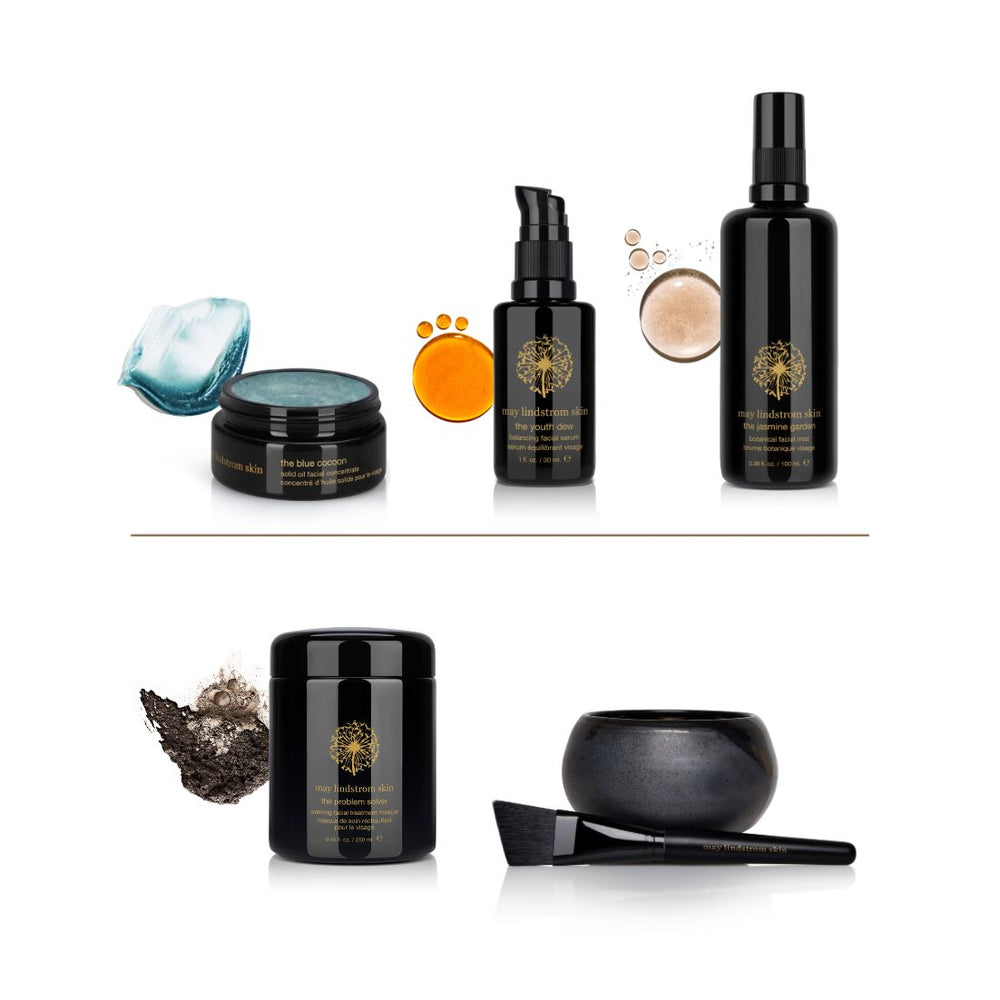 Collection of black skincare products with gold labels on a white background