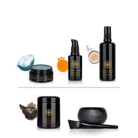 Collection of black skincare products with gold labels on a white background