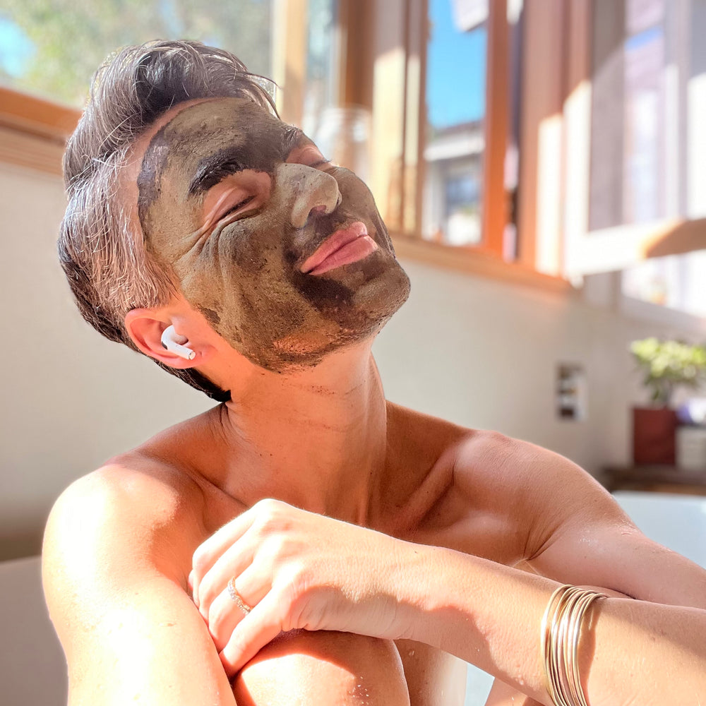 Woman applying a facial mask in a bright room