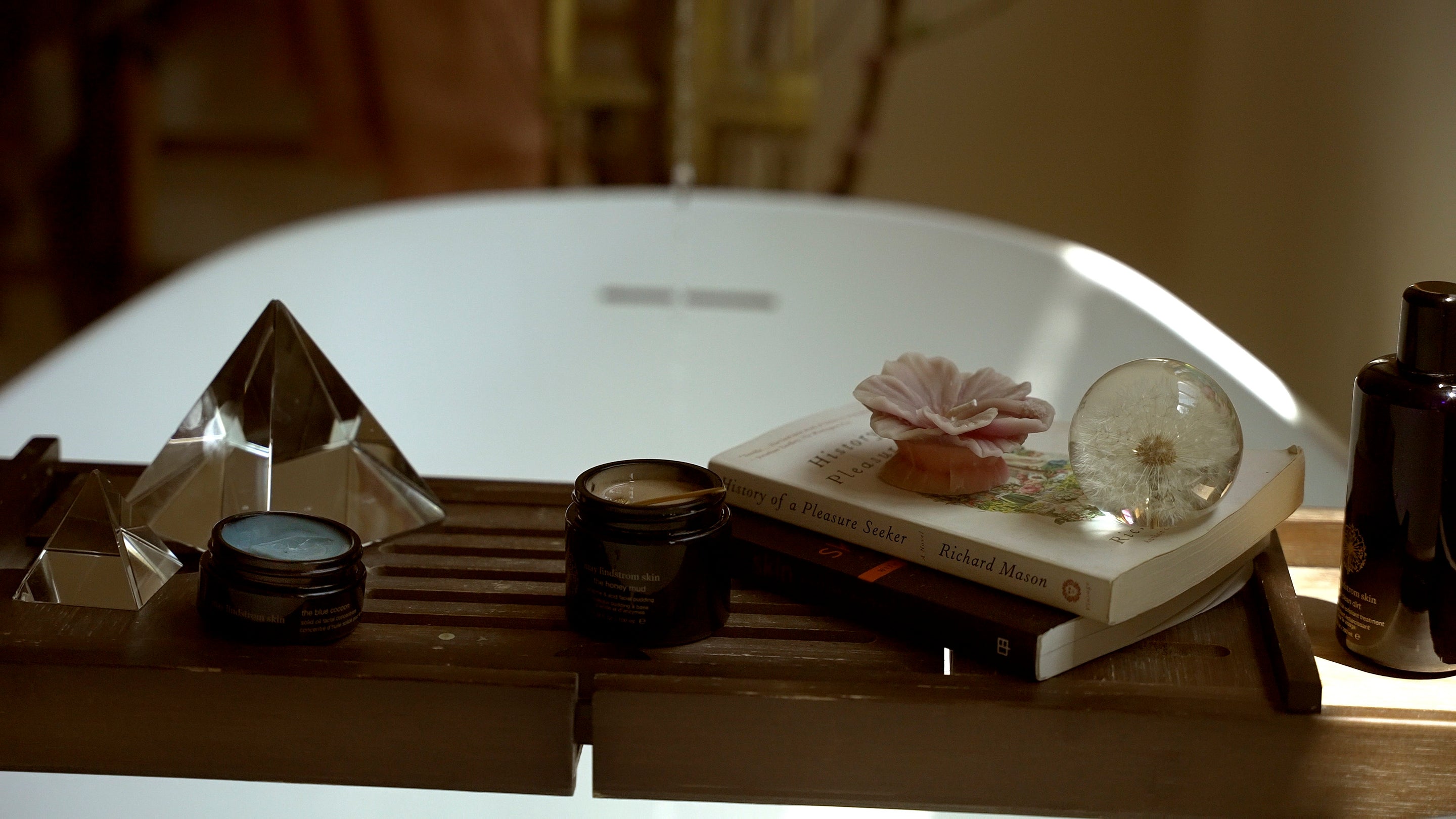 Decorative items on a table including a crystal ball, books, and May Lindstrom Skin products.