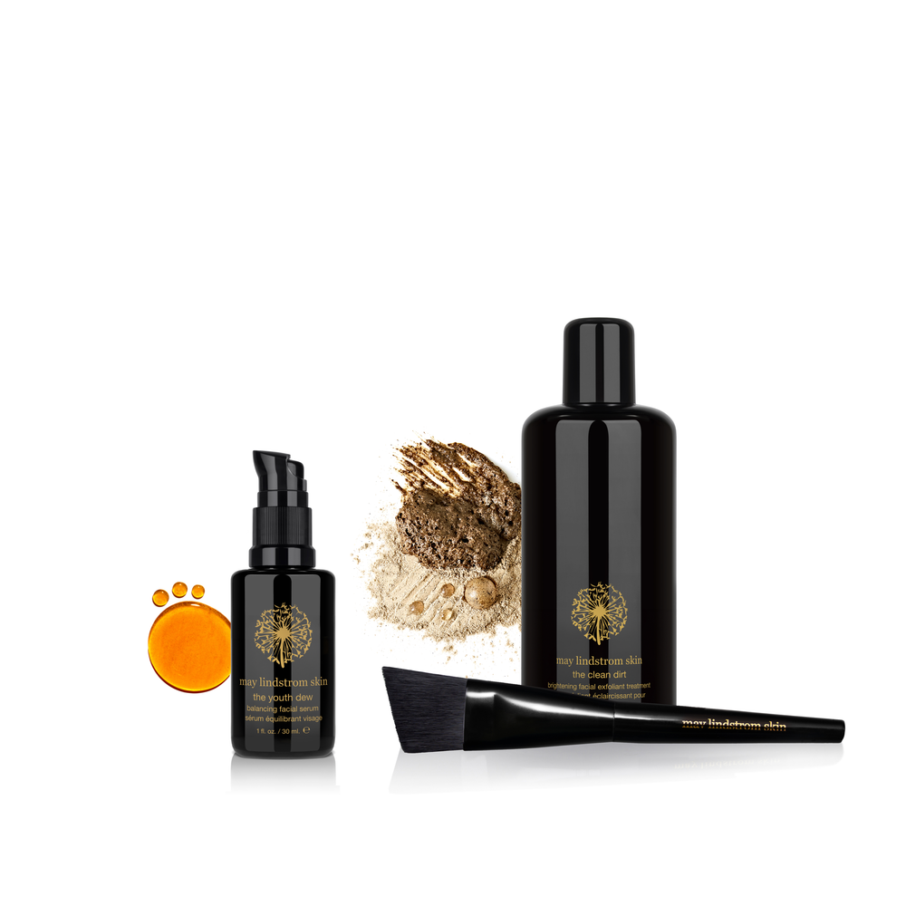 Set of skincare products including bottles, a brush, and a sponge on a white background